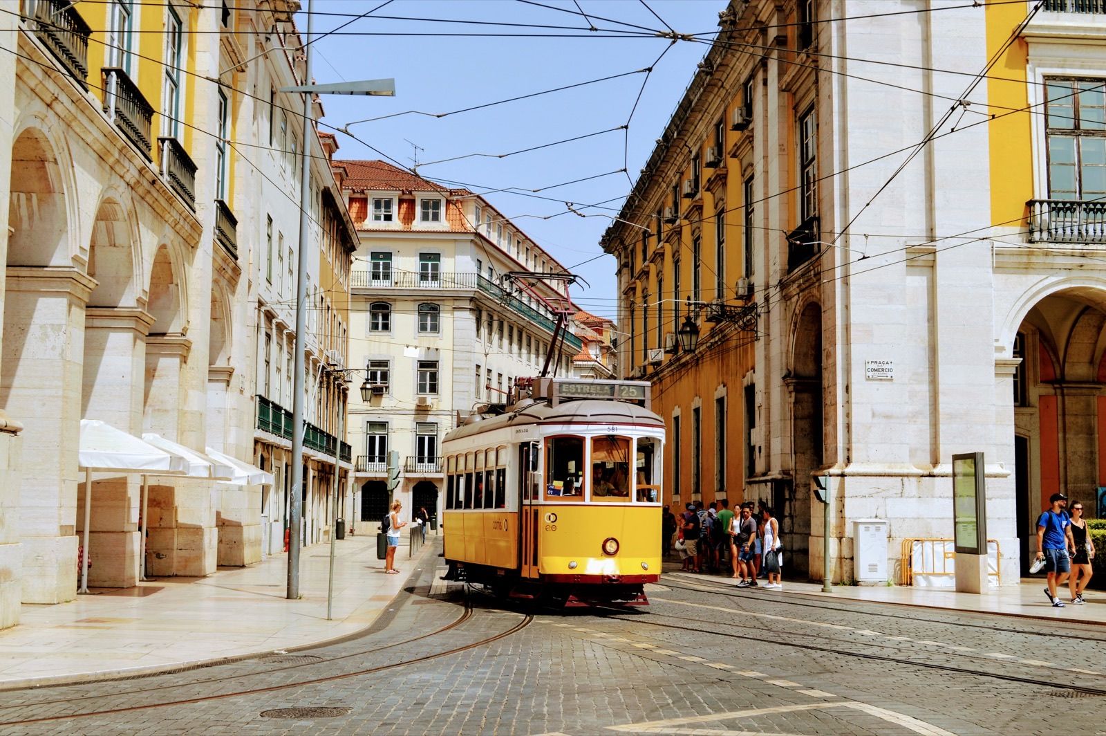 A yellow heritage tram on a cobbled street in Chiado, Lisbon